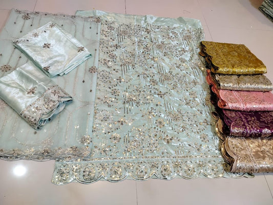 Decorative fabric with intricate patterns and embroidery on a tiled floor.